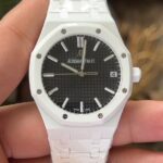 APS新品爱彼15500全陶瓷款式全新到货，凭借陶瓷材质与cal.4302一体机复杂功能的结合，成为工艺与创新的典范，既延续了皇家橡树的经典美学，又突破传统材质限制，堪称现代高级制表的标杆之作n1. 陶瓷材质的优势n高硬度与抗刮耐磨：采用精密陶瓷（如氧化锆）制成，硬度远超不锈钢，日常佩戴不易产生划痕，保持长久光泽。n轻量化与佩戴舒适：相比金属材质更轻盈，减轻腕部负担，适合长时间佩戴。n抗过敏与耐腐蚀：陶瓷化学性质稳定，不易引起皮肤敏感，且抗汗水和腐蚀。n独特质感：表面经精细抛光或哑光处理，呈现深邃光泽或低调质感，一共推出三款配色黑色白色和稀有的蓝色n2. 表壳与表带设计n一体式结构：APS表壳与表带无缝衔接，延续皇家橡树标志性八角形表圈和“Tapisserie”格纹表盘，陶瓷材质赋予现代感。n复杂工艺：APS采用陶瓷烧结成型难度极高，需精准控制温度与压力，成品率低，凸显技术实力。n细节处理：表带链节经倒角抛光，边缘柔和，佩戴贴合手腕；表壳厚度约10.5毫米，兼顾复杂工艺与佩戴舒适性。nAps出品只为精品