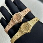 AP爱彼皇家橡树最新推出23mm迷你款石英女表。n​爱彼分别以黄金、玫瑰金与白金等三种贵金属分别诠释现代的皇家橡树迷你石英表，不止如此，手表的表壳、表圈与链带还加入珠宝设计师Carolina Bucci几年前（切确来说是2016年）与爱彼合作催生的独家霜金工艺，大致而言这种工艺是用钻石工具在K金表面锤击出细微凹痕，等到凹痕数量一多，手表整体看起来就像外观镶满钻石般闪闪动人。