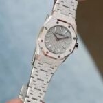AP爱彼皇家橡树最新推出23mm迷你款石英女表。n​爱彼分别以黄金、玫瑰金与白金等三种贵金属分别诠释现代的皇家橡树迷你霜金石英表，不止如此，手表的表壳、表圈与链带还加入珠宝设计师Carolina Bucci几年前（切确来说是2016年）与爱彼合作催生的独家霜金工艺，大致而言这种工艺是用钻石工具在K金表面锤击出细微凹痕，等到凹痕数量一多，手表整体看起来就像外观镶满钻石般闪闪动人。